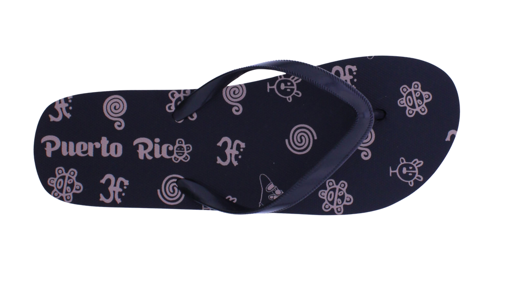 A single dark navy blue flip-flop sandal with a pattern of light purple Puerto Rican cultural symbols, including the San Andres shell, the Guatemalan quetzal bird, and the text 'Puerto Rico'.