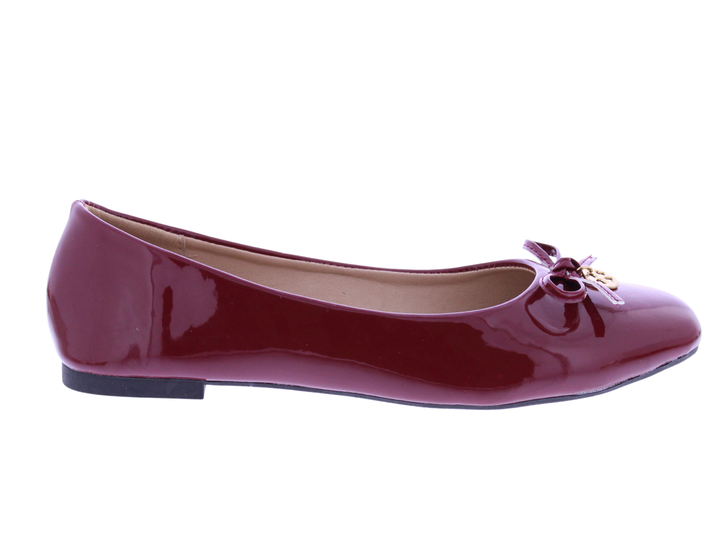 Shiny red ballet flat shoe on a white background