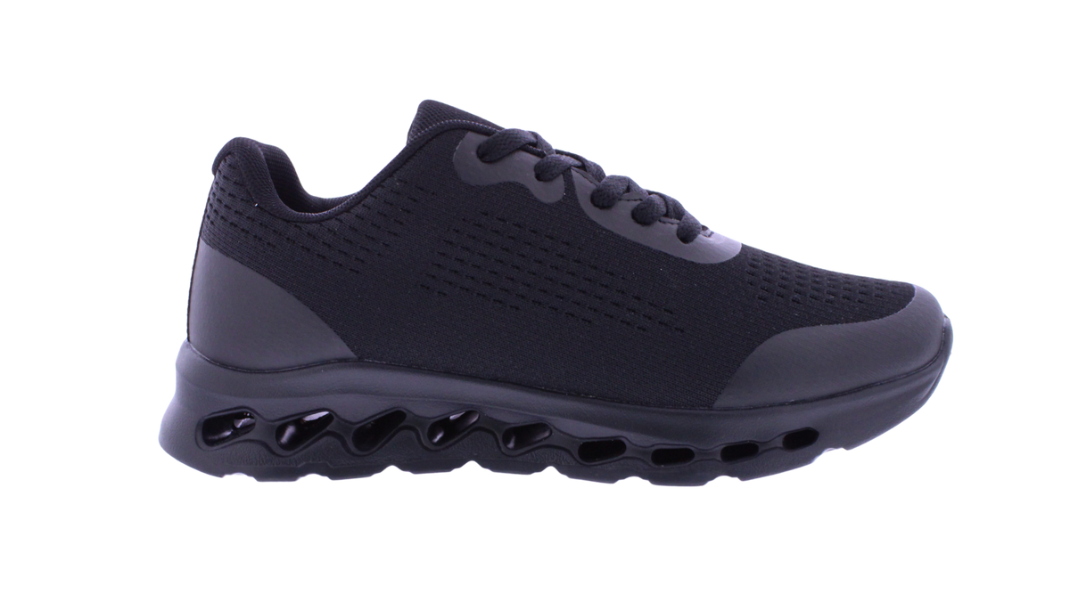 A black athletic sneaker with a textured mesh upper, matching black laces, and a distinctive wavy, hollow black sole, shown from a side profile on a white background.